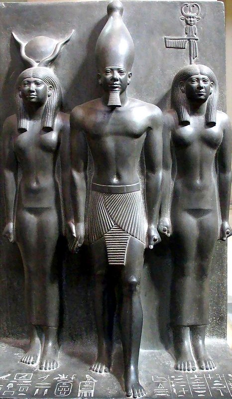 Triad of Menkaure The king accompanied by Hathor and a Nome Goddess with the crouching jackal emblem of the nome of Cynopolis. Menkaure is wearing the white crown of Upper Egypt